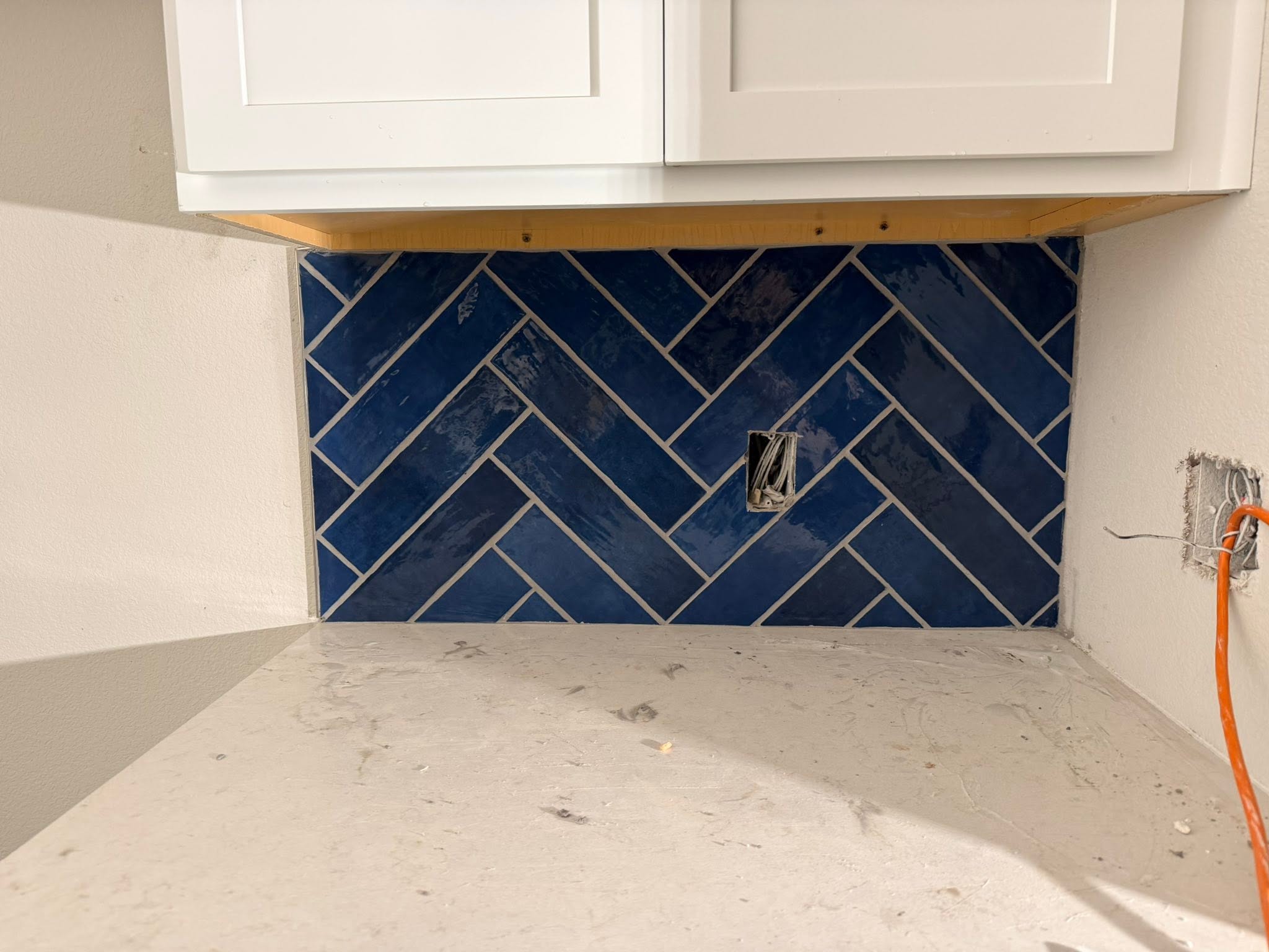 Kitchen backsplash with blue herringbone tile