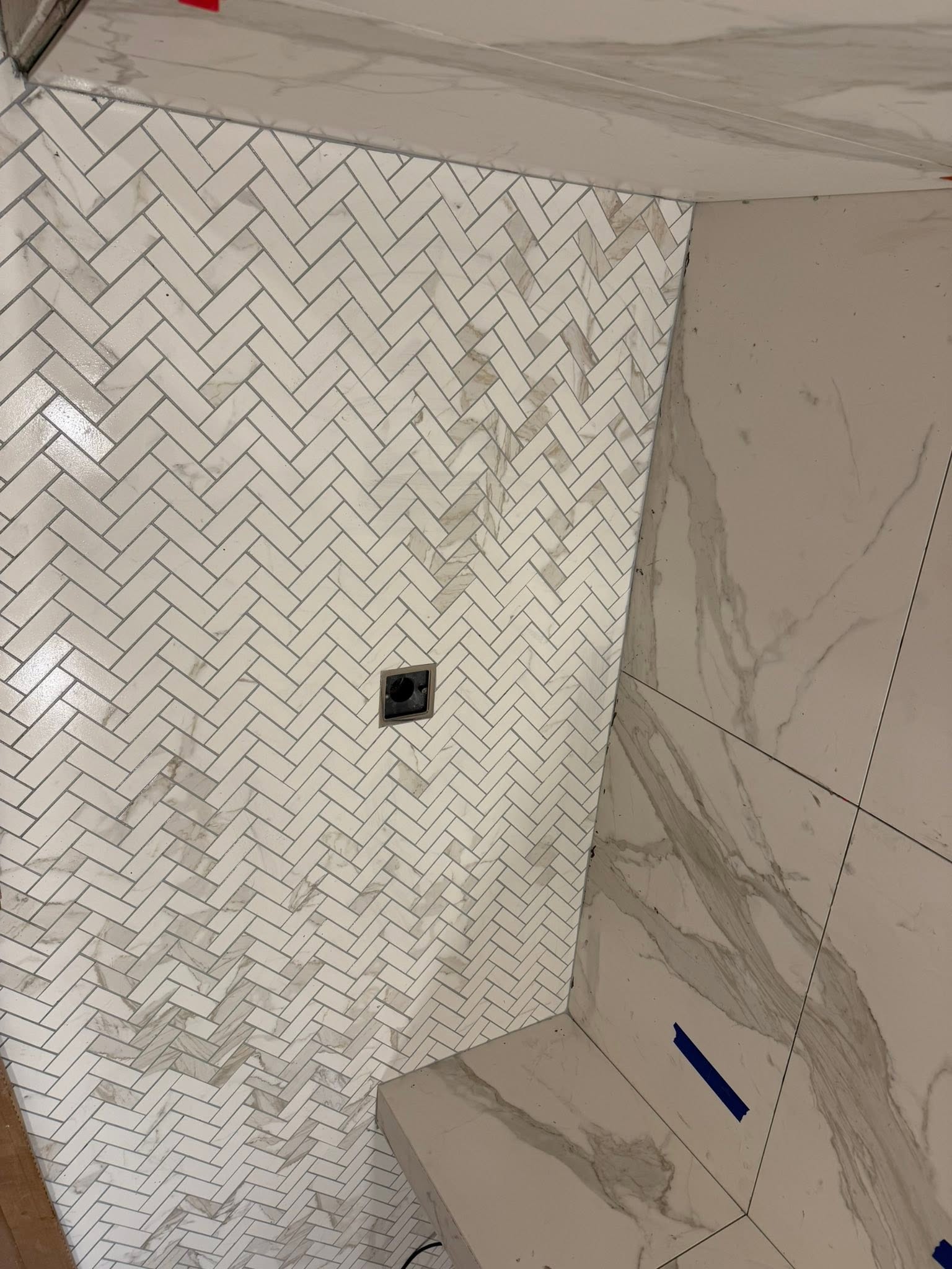 Shower remodel with marble herringbone tile